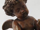 a statue of an angel holding a bird on a table