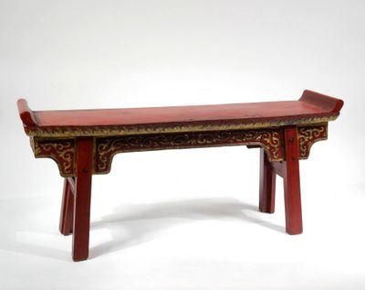 un banc rouge posé sur une surface blanche
