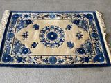 un tapis bleu et blanc posé sur un sol en béton