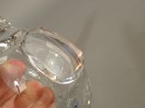 a person holding a clear glass bottle in their hand