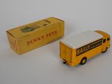 yellow and white toy bus and box on a white surface