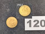 deux pièces d'or posées l'une à côté de l'autre sur une feuille de papier