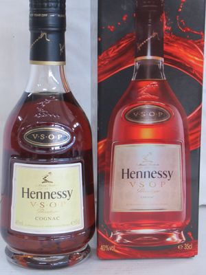 une bouteille de cognac Hennessy à côté d'une boîte de brandy