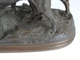 a bronze statue of a dog and a cat on a rock