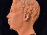 a close up of a clay head of a man with curly hair