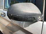 the side view mirror of a car is covered with a tarp