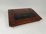 an old wooden box with a leather cover on it
