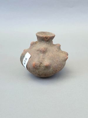 un petit vase muni d'une étiquette, posé sur une table
