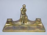brass figurine of a woman sitting on a bench