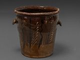 a brown vase that has some writing on it