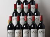 Des bouteilles de vin rouge sont posées sur une table devant un mur blanc.