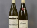 two bottles of wine sitting on top of a table next to each other