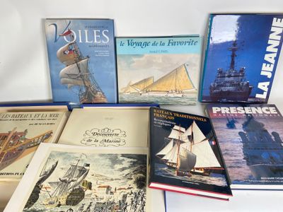 several books on a white surface with a ship in the background