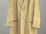 beige coat hanging on a hanger on a gray wall