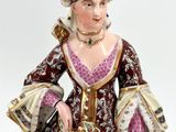 an image of a figurine of a woman wearing a dress and holding a purse