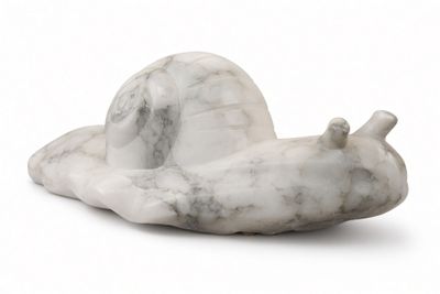 a white marble snail sitting on a white surface