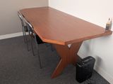 a wooden table with two chairs and a laptop on it