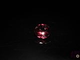 an image of a pink crystal ball on a black surface