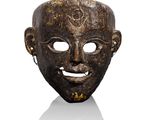 gros plan d'un masque en bois sur une surface blanche