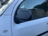 une petite voiture blanche garée dans un parking