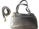 black leather purse with gold hardware and strap on a white background