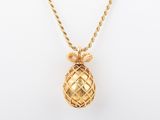a gold pineapple pendant on a gold chain