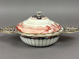 a white and red bowl with a lid on a gray surface
