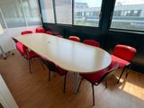 a long table with red chairs in the middle of a room