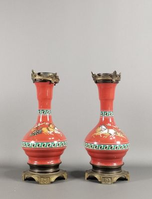 une paire de vases rouges ornés de motifs verts et dorés