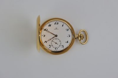 une montre de poche en or sur une surface blanche