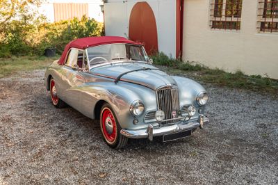une voiture argentée et rouge garée devant un immeuble