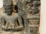 statue of a person sitting in a lotus position on a chair