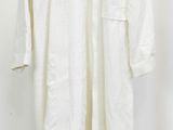 une photo d'une chemise blanche suspendue à un cintre accroché au mur