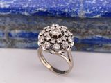 un gros plan d'une bague sertie de diamants en grappe sur une pierre bleue