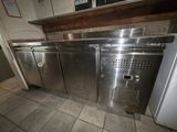 a stainless steel counter top with a refrigerator in the background