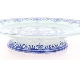 a blue and white plate on a stand on a white surface