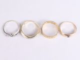 five different colored rings sitting on top of each other on a white surface