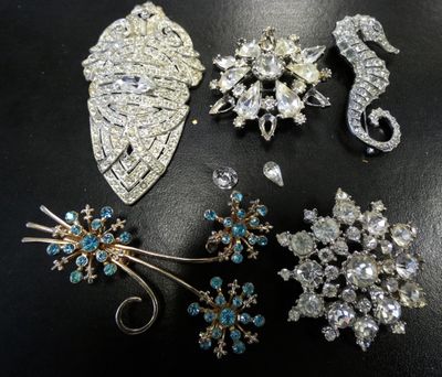 some of the brooches are sitting on a black surface