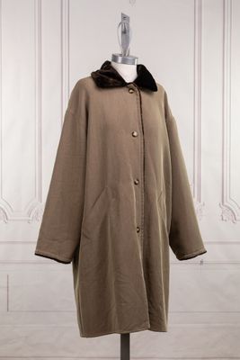 an image of a coat with a fur collar on a mannequin stand