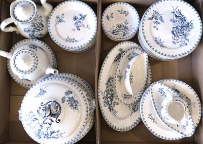une boîte remplie d'assiettes et de tasses en porcelaine bleue et blanche