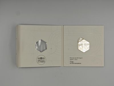 a silver coin sitting on top of a white box