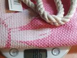 a pink and white bag on a scale on a table