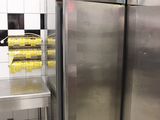 des réfrigérateurs en acier inoxydable dans une cuisine professionnelle dotée d'un sol en carrelage blanc