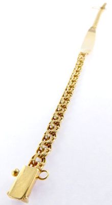 a close up of a gold chain bracelet with a gun on it