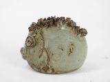 a small ceramic hedge sitting on a white surface