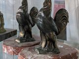 deux statues de coqs exposées dans une vitrine