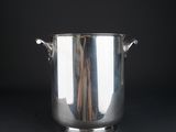 silver plated ice bucket with handles and handles on a black background