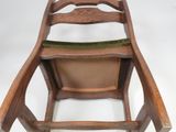 a wooden chair with a green seat on a white background