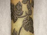 un vase orné d'un motif de feuilles