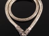 a silver snake head necklace on a black background